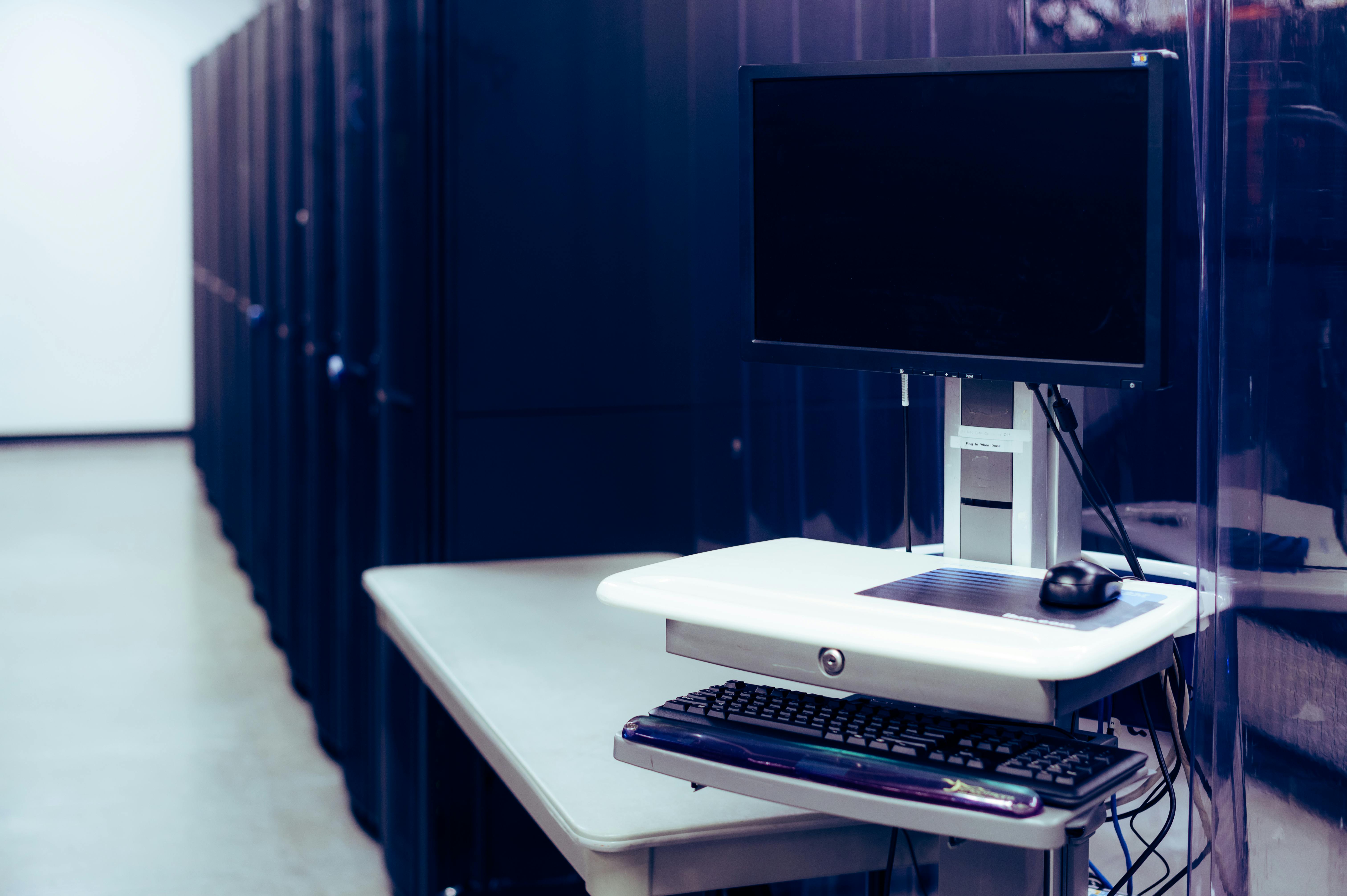 Workstation positioned beside rows of server racks